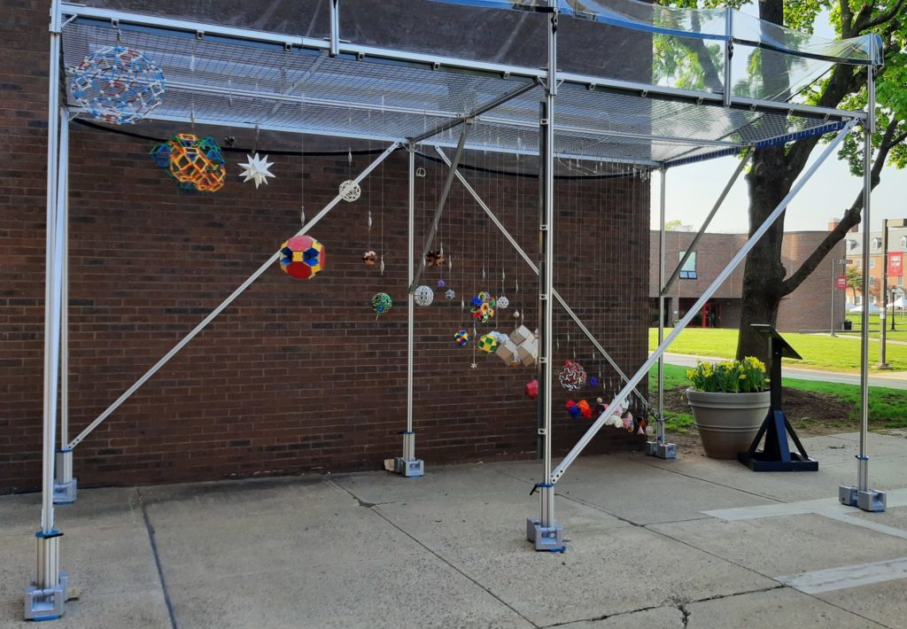 Many polyhedra hanging in a metal framework.